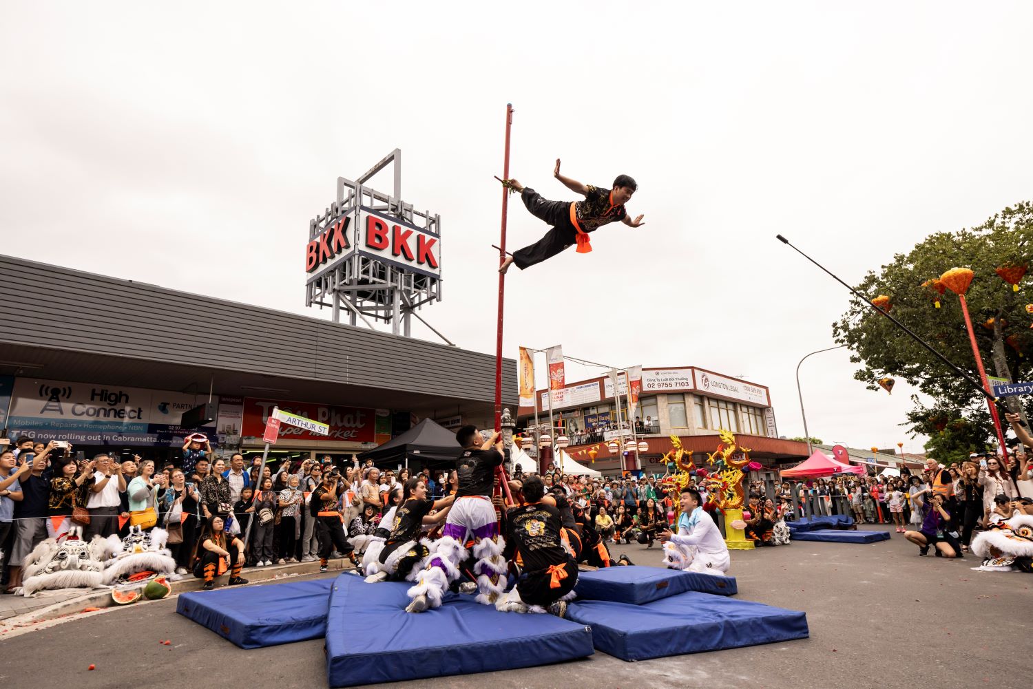 A lion dancer walking on the high stick